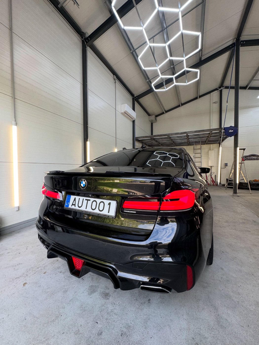 Juodas BMW po poliravimo Auto Korekcija studijoje su šešiakampėmis lempomis